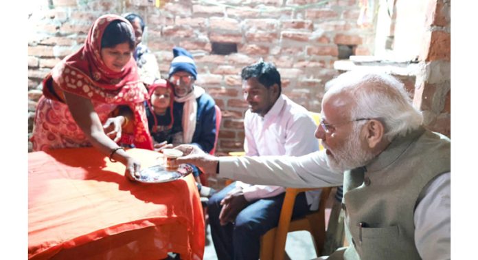 PM Narendra Modi taking tea at the residence of a Dalit woman in Ayodhya.