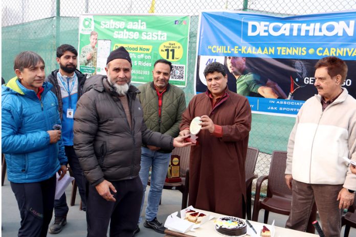 Winner being presented trophy during 'Decathlon Chillai-Kalan Tennis Carnival' at Gindun Stadium Rajbagh on Sunday. -Excelsior/Shakeel