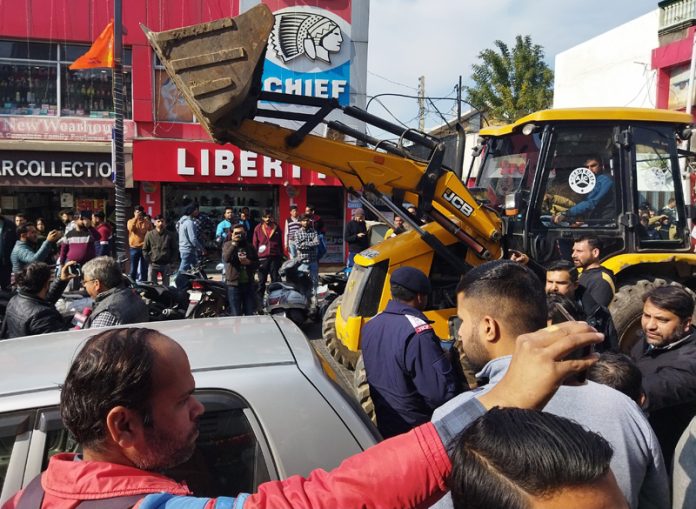 JCB machine in action during anti-encroachment drive at Apsra Road in Gandhi Nagar area on Saturday.