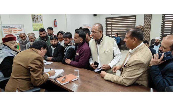 Senior BJP leader Devender Singh Rana hearing public grievances at party headquarters.