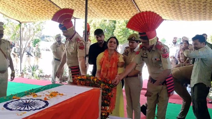 Wife of PSI Deepak Sharma laying wreath on body of the martyr.