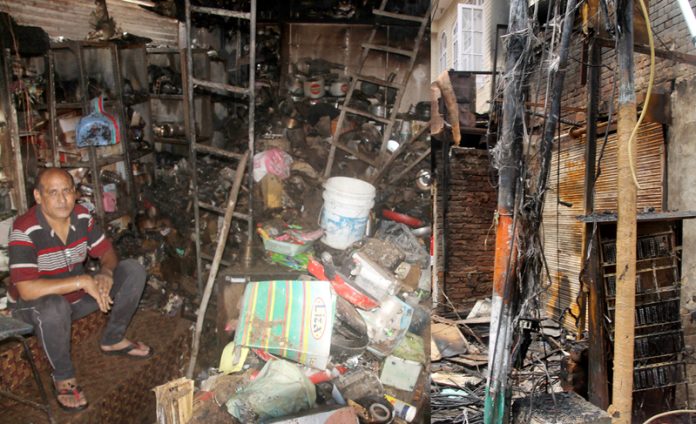 Owner of a gutted shop sits disappointed at Purani Mandi on Saturday. -Excelsior/Rakesh