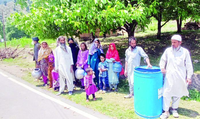 Locals collecting water from plasic tanks.