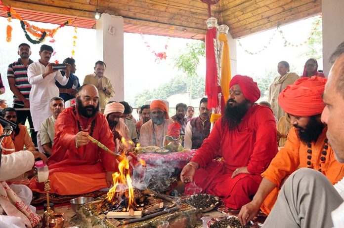 Deependra Giri, Mahant of holy mace of Shri Amarnath Ji performing hawan and Bhoomi Pujan along with Sadhus and other devotees at Pahalgam on Sunday. -Excelsior/Sajjad Dar