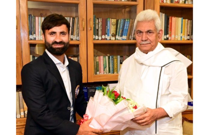 J&K cricketer Parvez Rasool presenting a bouquet to LG Manoj Sinha at Raj Bhawan.