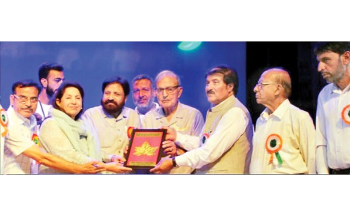 Chief guest Dr Sheikh Mustafa Kamaal accompanied by JKRDS Chairman, Mubarak Gul presenting award during a function in Srinagar.