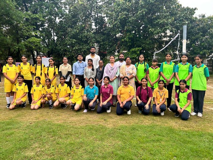 Volleyball teams posing along with teaching staff.