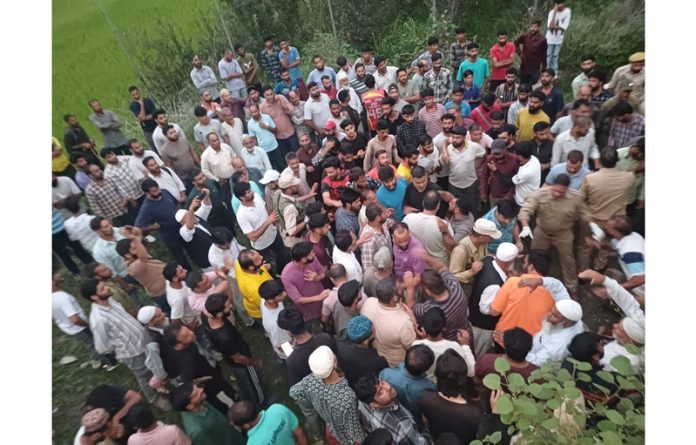 People and policemen in large number assembled at the spot where body of PSO of BJP leader was found lying in the field at Surankote. -Excelsior/ Waseem