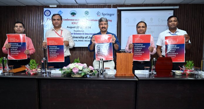 Arun Manhas and others releasing a poster during International Conference on Recent Innovations in Computing at CUJ.