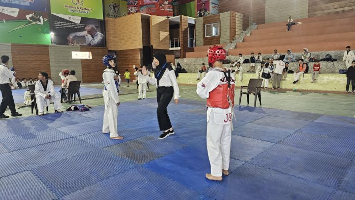 Caption: Taekwondo athletes in action during the championship at Budgam.