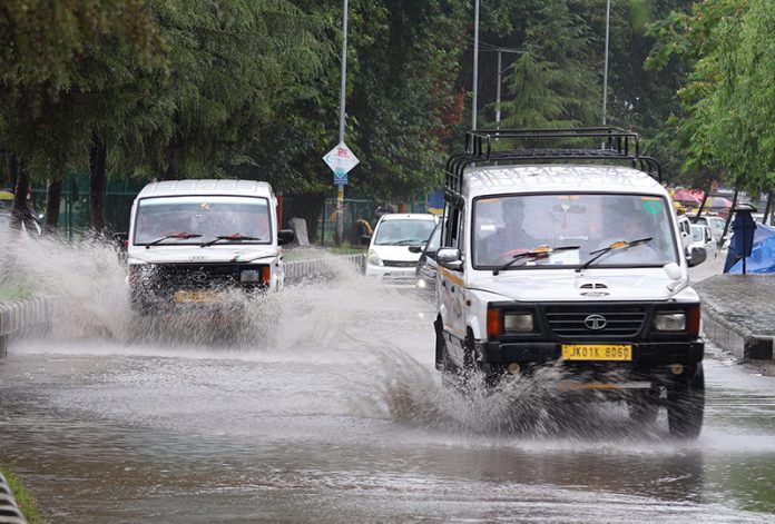 Vehicles move on a waterlogged road in Srinagar. — Excelsior/Shakeel