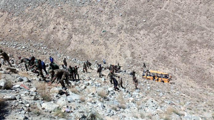 Security personnel and locals shift victims from a gorge after bus accident at Durbuk, Leh on Thursday