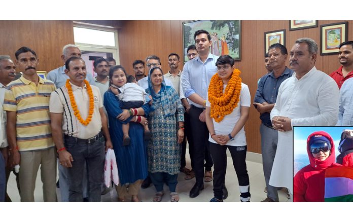 Suman Verma posing along with DC, Kathua Dr. Rakesh Minhas and family members (L) and Suman holding national flag on top of Mount Elbrus (R).