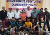 Weightlifters posing along with dignitaries during opening ceremony.