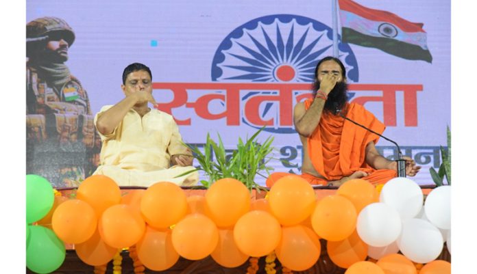 Patanjali Yogpeeth President, Swami Ramdev and Acharya Balkrishna performing Pranayama during a function to celebrate Independence Day in Haridwar.