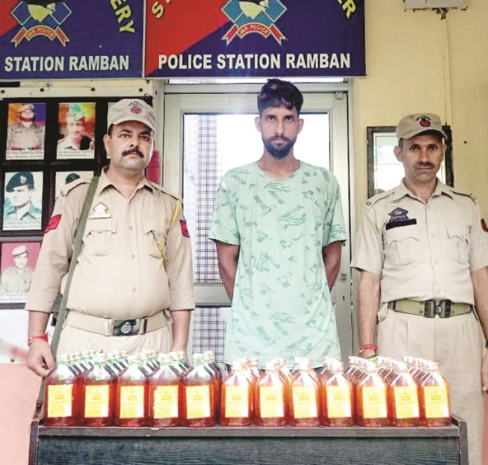 Cops in Ramban present a bootlegger along with illicit liquor recovered from him.