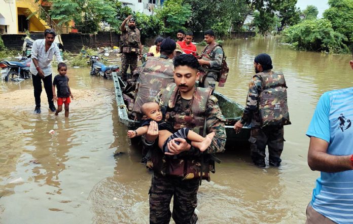 Capt Vishal Magotra of Bishnah rescuing a child in the floods at Gujarat.