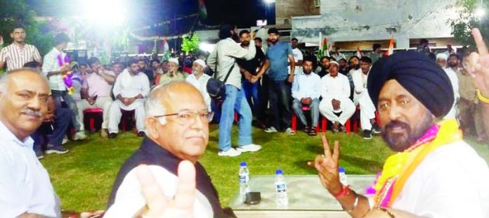 JKPCC chief T H Karra, flanked by Cong candidate T S Tony during public meeting in Bahu constituency.