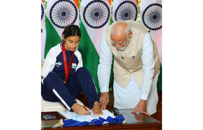 Paris Paralympics medallist from Jammu and Kashmir Sheetal Devi presenting a special autographed jersey to Prime Minister Narendra Modi.