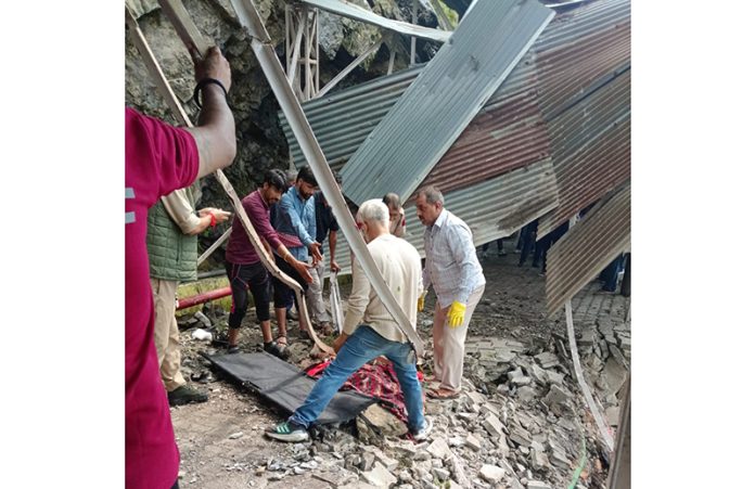 Body of female pilgrim being retrieved from damaged iron structure following landslide. — Excelsior/Romesh Mengi