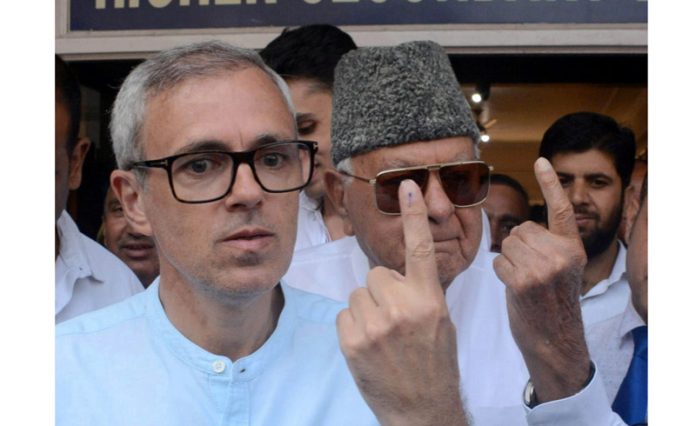 NC president Farooq Abdullah and party's vice president Omar Abdullah showing indelible ink marked fingers after casting their vote in Srinagar. . -Excelsior/Shakeel