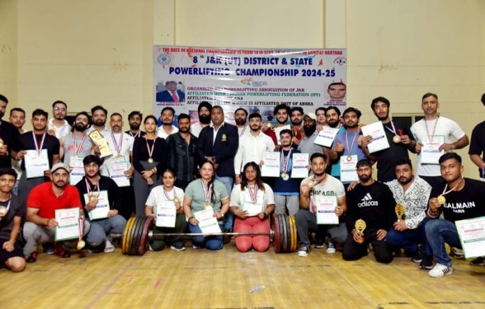 Winners in various categories of Powerlifting Championship posing with medals and certificates.