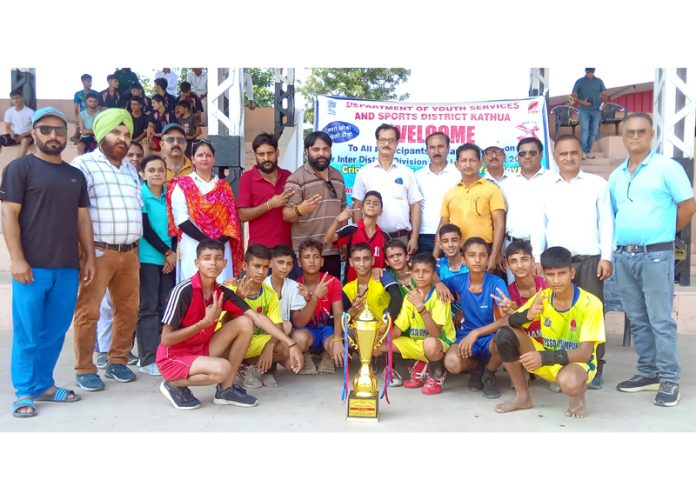 Winning team posing along with dignitaries and trophy.