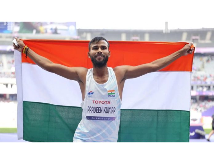 High jumper Praveen Kumar posing with national flag after winning gold medal in Paralympic.