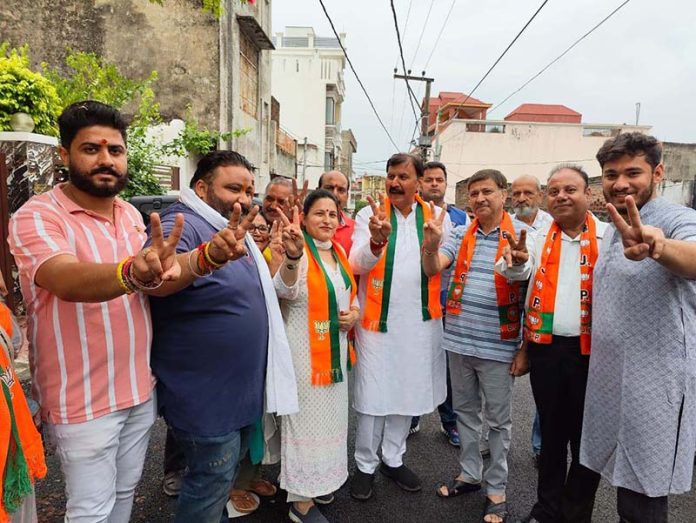 BJP leader Arvind Gupta, along with the party workers and supporters, showing the victory sign.