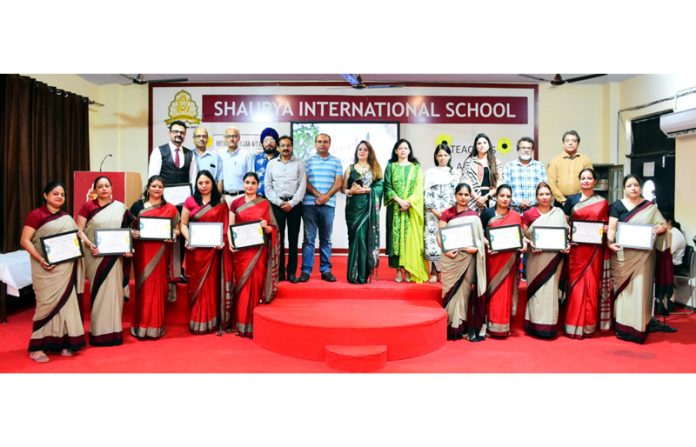 Teachers posing along with mementos during a programme.